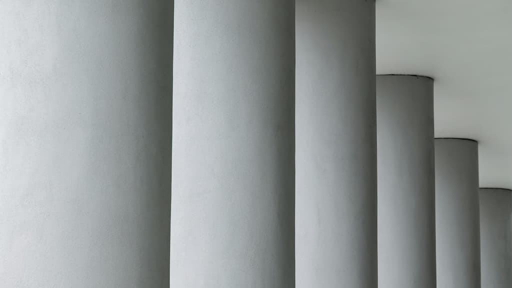 A row of pale round columns receding to the right
